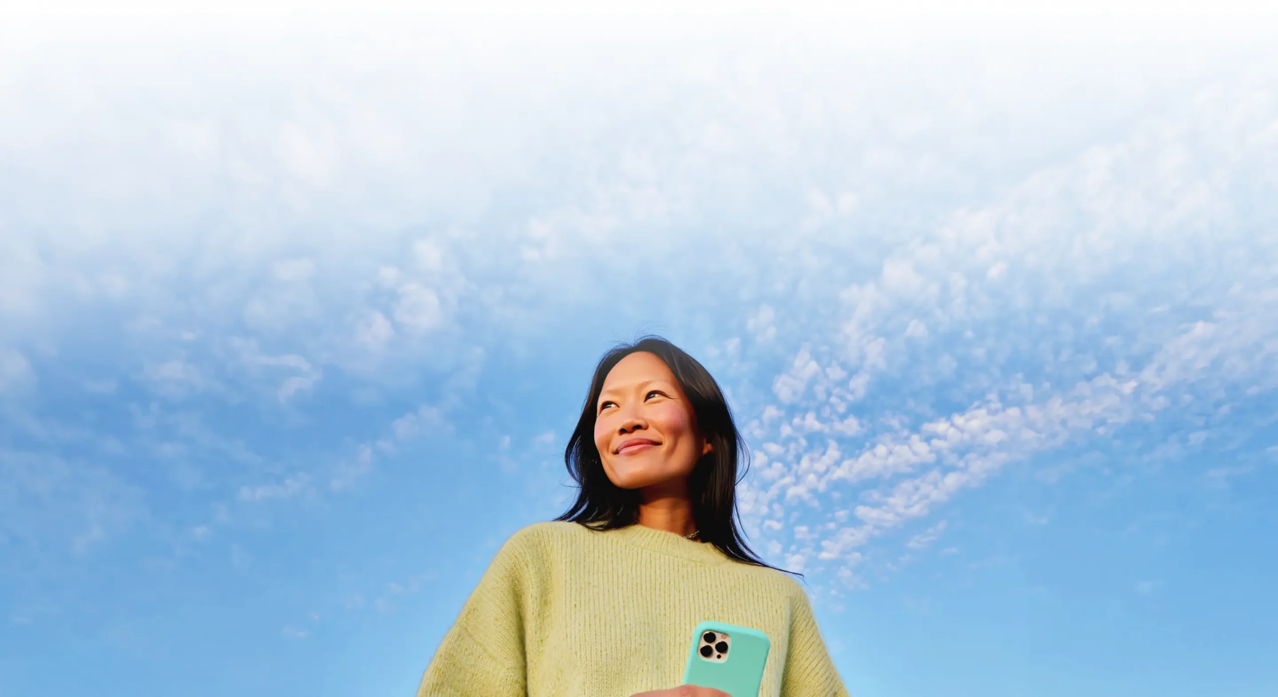Woman smiling while holding her phone